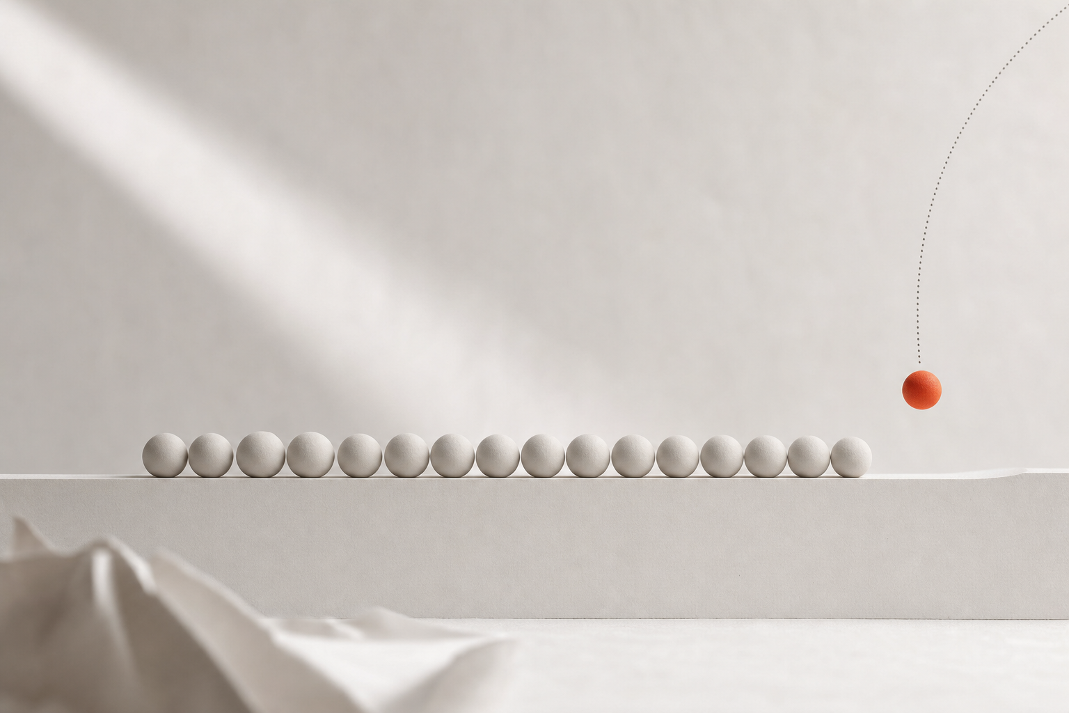 A long row of small pale spheres rests evenly spaced along a paper-white ledge while one burnt-orange sphere descends toward the empty next place on a fine dotted arc: the quiet cadence of one lead arriving every day.
